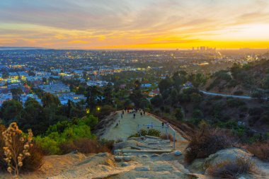 Los Angeles, Kaliforniya - 3 Aralık 2024: Runyon Canyon Park 'ında Los Angeles üzerinden gün batımına hayran olan bir grup yürüyüşçüyü geniş açı çekimleri.