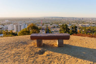 Los Angeles, Kaliforniya - 6 Ocak 2025: Runyon Canyon Parkı 'ndaki Los Angeles ufuk çizgisine bakan Max Leavitt anıtından günbatımı manzarası.