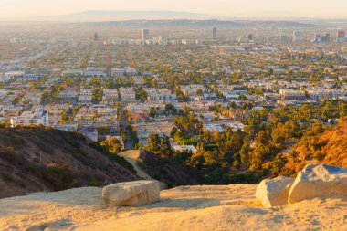 Los Angeles, Kaliforniya - 6 Ocak 2025: Runyon Canyon Parkı 'ndan manzara manzarası gün batımında Los Angeles' ın genişleyen şehrini yakalıyor, kentsel gelişimi ve doğal çevreyi gözler önüne seriyor.