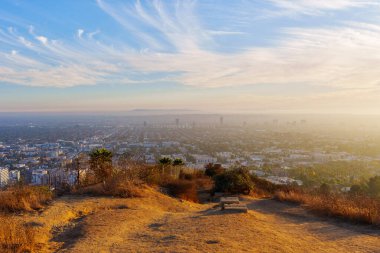Los Angeles, California - 3 Aralık 2024: Los Angeles 'ın altın saatindeki panoramik manzarası, şehir manzarası detayları, hafif ışıklandırma, uzak dağlar ve açık bir gökyüzü.