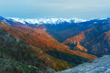 Gün batımında Sequoia Ulusal Parkı sıradağlarının nefes kesici manzarası, canlı renkler ve geniş açılı perspektifli kar örtülü zirveler sergiliyor..