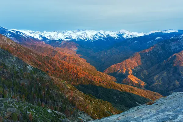 Gün batımında Sequoia Ulusal Parkı sıradağlarının nefes kesici manzarası, canlı renkler ve geniş açılı perspektifli kar örtülü zirveler sergiliyor..