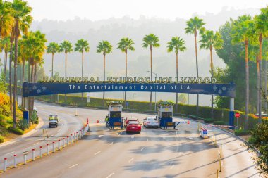 Los Angeles, California - 24 Aralık 2024: Universal Stüdyoları 'nın ikonik girişi Hollywood' da palmiye ağaçları ve puslu bir zemin yer alıyor..