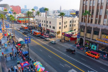 Los Angeles, Kaliforniya - 23 Aralık 2024: Los Angeles şehir merkezinde renkli binalar, palmiye ağaçları ve yoğun trafiğin yer aldığı canlı sokak manzarası, kentsel yaşamı gözler önüne seriyor.
