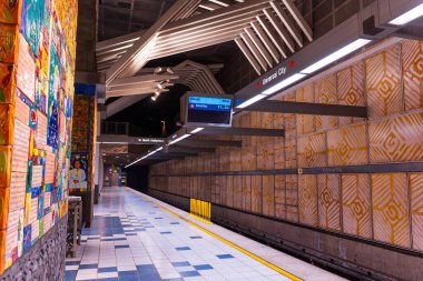 Los Angeles, California - 23 Aralık 2024: Evrensel Şehir Metro İstasyonu 'nun canlı fayanslar ve modern mimari içerikli görüntüsü, boş platform ve tabelaların sergilendiği.