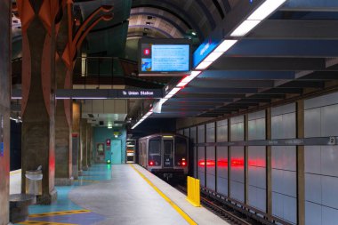 Los Angeles, California - 23 Aralık 2024: Hollywood / Highland Metro Tren İstasyonu, dijital tabela ve modern mimari unsurlarla perona gelen bir treni gösteriyor.