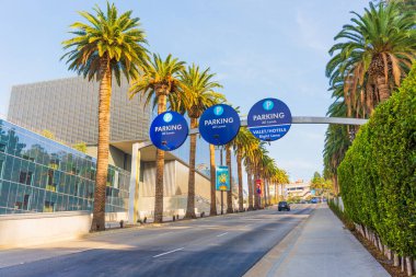 Los Angeles, Kaliforniya - 24 Aralık 2024: Los Angeles 'ta bir park girişinin geniş açılı görüntüsü, palmiye ağaçları ve parlak sabah ışığı altında açık tabelalar.