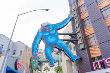 Los Angeles, Kaliforniya - 24 Aralık 2024: Büyük mavi goril Noel Baba şapkası takıyor ve Kaliforniya, Los Angeles 'ta güpegündüz elinde çelenk tutuyor..