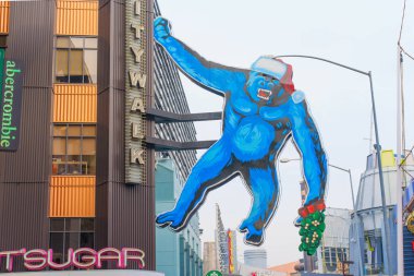 Los Angeles, Kaliforniya - 24 Aralık 2024: Noel Baba şapkalı büyük mavi goril Los Angeles, Kaliforniya 'daki Universal CityWalk' un üzerinde asılı, bayram sezonu için süslenmiş..