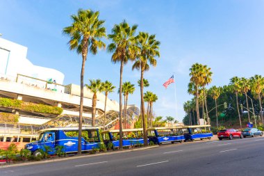 Los Angeles, Kaliforniya - 24 Aralık 2024: Gün ışığında Los Angeles, Universal CityWalk 'da Frankenstein otoparkının palmiye ağaçları ve mavi bir mekik tramvayı ile geniş açılı görüntüsü.