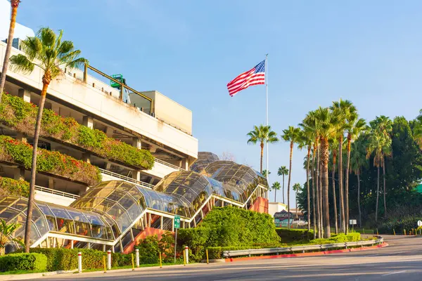 Los Angeles, Kaliforniya - 24 Aralık 2024: Universal CityWalk, Los Angeles, Kaliforniya 'da palmiye ağaçları ve Amerikan bayrağıyla Frankenstein otoparkının dış görünümü.