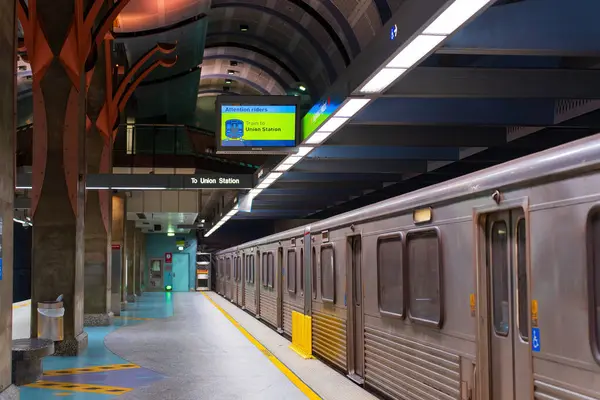 Los Angeles, California - 23 Aralık 2024: Hollywood / Highland Metro Tren İstasyonu 'nun iç görüntüsü Platform, tren ve tabelayı gösteriyor, parlak yapay ışıklandırmayla çekiliyor.