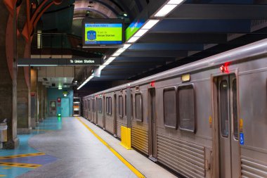 Los Angeles, Kaliforniya - 23 Aralık 2024: Los Angeles 'taki Hollywood / Highland İstasyonuna ulaşan bir metro treninin geniş açılı görüntüsü, modern mimari ve canlı ışıklandırmayı gözler önüne seriyor.