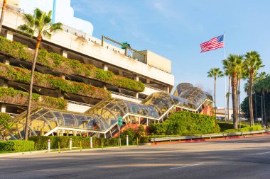 Los Angeles, California - 24 Aralık 2024: Universal CityWalk 'daki Frankenstein Otoparkı' nın geniş açılı görüntüsü, palmiye ağaçları ve bir Amerikan bayrağı.