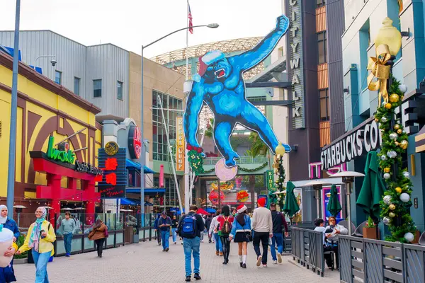 Los Angeles, California - 24 Aralık 2024: Los Angeles Universal CityWalk 'da canlı bir sokak sahnesi, yayalar ve büyük mavi bir goril figürü.