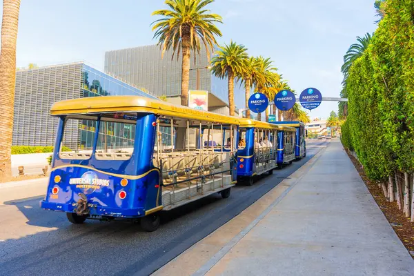 Los Angeles, Kaliforniya - 24 Aralık 2024: Vibrant Universal Stüdyoları Los Angeles 'ta palmiye çizgili bir yol boyunca park halinde, canlı mimari ve açık gökyüzü sergilenmektedir..