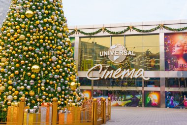 Los Angeles, Kaliforniya - 24 Aralık 2024: Canlı tatil ağacı Los Angeles Universal Cinema 'nın dışında altın ve gümüş süslemelerle bezenmiş, güpegündüz yakalanmıştır..