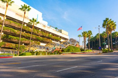 Los Angeles, Kaliforniya - 24 Aralık 2024: Gündüz vakti Los Angeles 'ta palmiye ağaçları ve Amerikan bayrağıyla Frankenstein otoparkının geniş açılı görüntüsü.