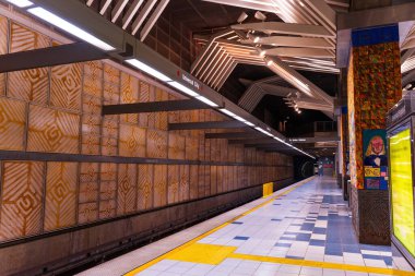 Los Angeles, California - 23 Aralık 2024: Universal City Metro Tren İstasyonunun geniş açılı görüntüsü modern mimari, canlı renkler ve boş platform.