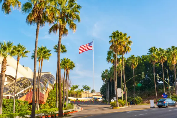 Los Angeles, Kaliforniya - 24 Aralık 2024: Gündüz vakti Los Angeles, Kaliforniya 'da Universal CityWalk' da Amerikan bayrağıyla palmiye ağaçlarının geniş açı çekimi.