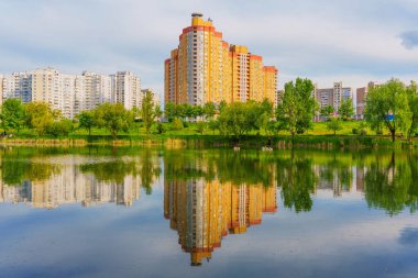 Ukrayna 'nın başkenti Kyiv' de sakin bir göle yansıyan renkli binaların geniş açılı görüntüsü..