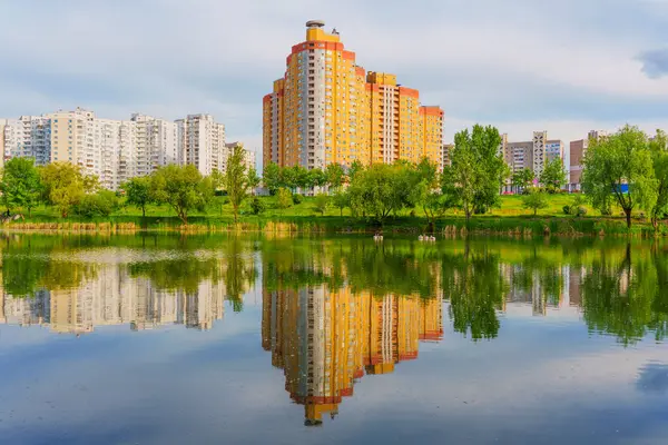 Ukrayna 'nın başkenti Kyiv' de sakin bir göle yansıyan renkli binaların geniş açılı görüntüsü..
