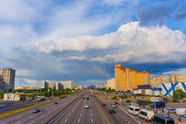 Kyiv, Ukrayna - 19 Mayıs 2025: Yoğun karayolu trafiğinin geniş açılı görüntüsü ve Kyiv 'deki konut binaları dramatik bir gökyüzü altında.