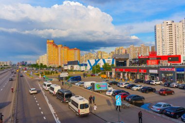 Kyiv, Ukrayna - 19 Mayıs 2025: Poznyaky Metro İstasyonu 'ndaki şehirlerarası otobüslerin görüntüsü, Bazhana Bulvarı' ndaki trafik ve bulutlu bir gökyüzünün altındaki alışveriş merkezleri.