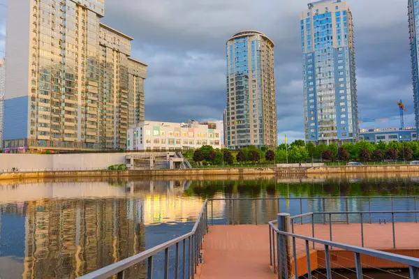 Kyiv, Ukrayna - 19 Mayıs 2025: Nehir AVM iskelesinin geniş açılı görüntüsü, Kyiv 'deki bulutlu gökyüzünün altındaki suya yansıyan River Stone konut kompleksi.