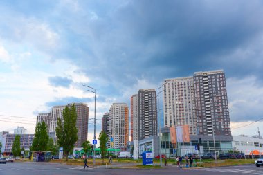 Kyiv, Ukrayna - 19 Mayıs 2025: Kentsel mimari ve bulutlu gökyüzünü gösteren Kyiv 'de bir araba galerisi ile birlikte çağdaş bir konut kompleksinin görüntüsü.