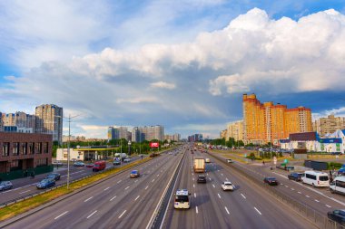 Kyiv, Ukrayna - 19 Mayıs 2025: Bazhana Bulvarı 'ndaki trafiğin geniş açılı görüntüsü Poznyaky, Kyiv' deki modern binalar bulutlu gökyüzü altında dinamik bir şehir ortamı gösteriyor.