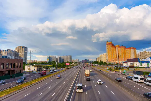 Kyiv, Ukrayna - 19 Mayıs 2025: Bazhana Bulvarı 'ndaki trafiğin geniş açılı görüntüsü Poznyaky, Kyiv' deki modern binalar bulutlu gökyüzü altında dinamik bir şehir ortamı gösteriyor.
