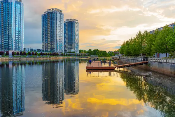 Kyiv, Ukrayna - 19 Mayıs 2025: Ukrayna 'nın Kyiv kentindeki Riverstone konut kompleksinin manzarası, günbatımının su üzerindeki yansımaları, modern mimari ve huzurlu çevreyi gözler önüne seriyor..
