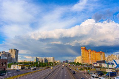 Kyiv, Ukrayna - 19 Mayıs 2025: Kyiv 'in Poznyaky ilçesinin geniş açılı görüntüsü, bir otoyol, konut binaları ve gökyüzünde dramatik bulutlar.