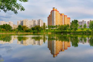 Kyiv, Ukrayna - 19 Mayıs 2025: Poznyaky Gölü 'nün sakin manzarası, Ukrayna' nın başkenti Kyiv 'deki modern yerleşim yerlerini yansıtıyor..