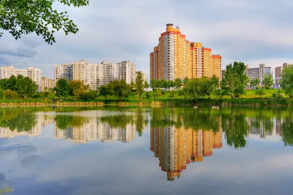 Kyiv, Ukrayna - 19 Mayıs 2025: Poznyaky Gölü 'nün sakin manzarası, Ukrayna' nın başkenti Kyiv 'deki modern yerleşim yerlerini yansıtıyor..