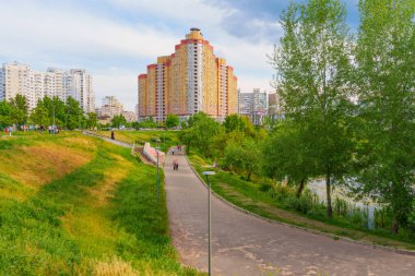 Kyiv, Ukrayna - 19 Mayıs 2025 Poznyaky Gölü 'nün yanındaki yerleşim alanının geniş açılı görüntüsü, yeşil alanlar, yollar ve bulutlu gökyüzü altındaki modern binalar.