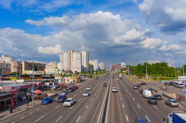 Kyiv, Ukrayna - 19 Mayıs 2025: Güneşli bir günde Kharkivska metro istasyonu yakınlarındaki trafik, binalar ve şehir yaşamını gösteren Bazhana Bulvarı.