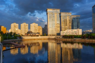 Kyiv, Ukrayna - 19 Mayıs 2025: Ukrayna 'nın başkenti Kyiv' de sakin bir su yüzeyine yansıyan modern binaların geniş açılı görüntüleri.