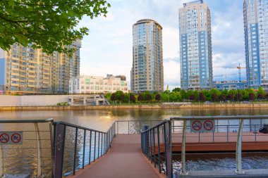 Kyiv, Ukrayna - 19 Mayıs 2025: River Mall rıhtımındaki Dnipro Nehri 'nin panoramik manzarası, modern gökdelenleri ve huzurlu bir atmosferi gözler önüne seriyor.