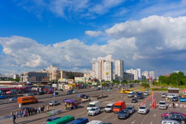 Kyiv, Ukrayna - 19 Mayıs 2025: Bazhana Caddesi 'nin güneşli bir günde Ukrayna' nın Kyiv kentindeki Kharkivska Metro İstasyonu yakınlarında trafik ve yayalarla dolu olduğu gösteren hava manzarası.