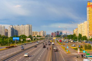 Kyiv, Ukrayna - 19 Mayıs 2025: Kyiv 'de modern binaların ve açık bir gökyüzü altında araç trafiğinin yer aldığı yoğun bir yolun geniş açılı görüntüsü.
