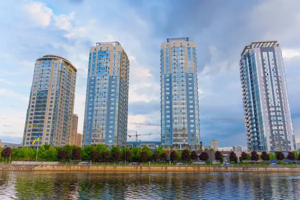 Kyiv, Ukrayna - 19 Mayıs 2025: Kyiv 'deki Riverstone kompleksinde bulunan dört konut kulesinin geniş açılı görüntüsü, altın saat boyunca çağdaş mimari ve nehir kenarı manzarasını gösteriyor.