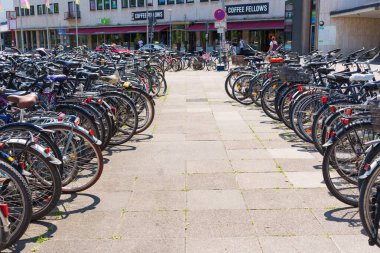 Heidelberg, Almanya - 21 Haziran 2025: Bir kahve dükkanının önünde bisikletle dolu geniş bir bisiklet parkı.