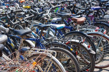Heidelberg, Almanya - 21 Haziran 2025: Parlak gün ışığı altında hareketli bir şehir alanına park edilmiş yoğun bisiklet dizisi, çeşitli stiller ve renkler sergileniyor.