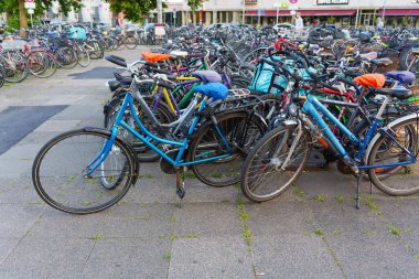 Heidelberg, Almanya - 21 Haziran 2025: Kentsel bisiklet parkına park edilmiş yoğun bisiklet dizisi, gündüz saatlerinde çeşitli renk ve stilleri gösteriyor.