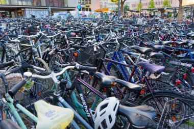 Heidelberg, Almanya - 21 Haziran 2025: Parlak gün ışığı altında çeşitli bisikletlerin yer aldığı kalabalık bir park yeri, renklerini ve tasarımlarını gözler önüne seriyor.