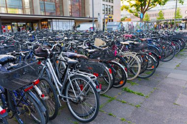 Heidelberg, Almanya - 21 Haziran 2025: Çeşitli bisikletlerle dolu kalabalık park alanı, gündüz saatlerinde şehir merkezinde şehir ulaşımını gözler önüne seriyor.