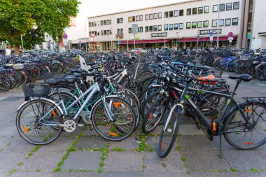 Heidelberg, Almanya - 21 Haziran 2025: Sabahın erken saatlerinde bir kahve dükkanının yakınında bisiklet parkı ile dolu.