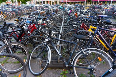 Heidelberg, Almanya - 21 Haziran 2025: Kalabalık bisiklet park alanı çeşitli bisikletlerle dolu, güpegündüz yakalandı.